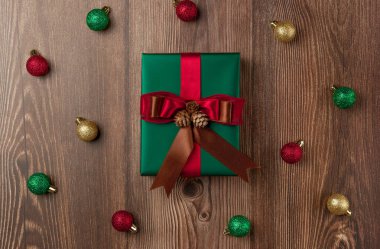 Ahşap arka planda Noel süsleri olan Noel hediyesi kutusu. Üst görünüm.