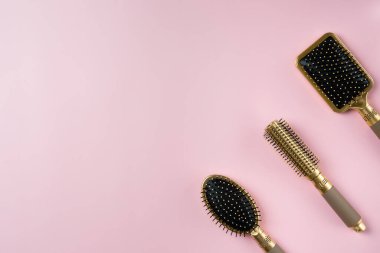 Pembe arka planda üç saç fırçası. Boşluğu kopyala.