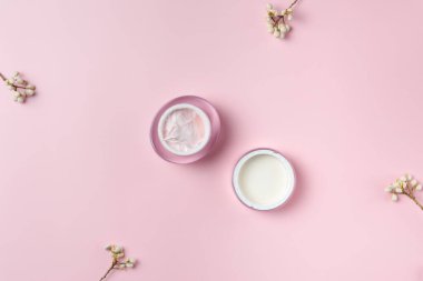 Krema kavanozu pembe arka planda izole edilmiş, üst görünümde.