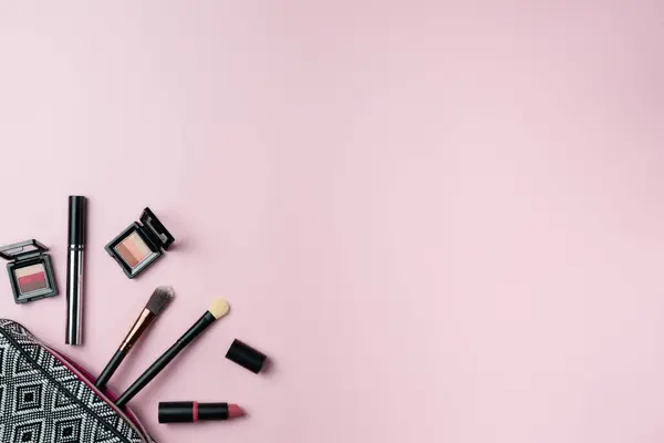 Kozmetikler pembe arka planda kozmetikten düşüyor