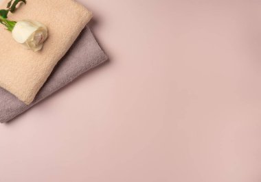Pastel pembe arka planda gül rengi havlular. Spa konsepti