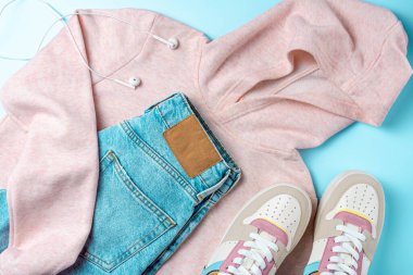 Mavi arka planda gençler için kıyafetler. Gençler için kıyafet. Üst manzara, düz uzanma.