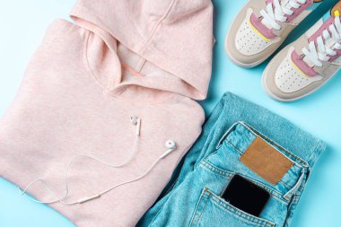 Mavi arka planda gençler için kıyafetler. Gençler için kıyafet. Üst manzara, düz uzanma.