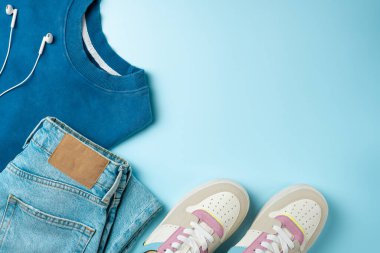 Mavi arka planda gençler için kıyafetler. Gençler için kıyafet. Üst manzara, düz uzanma.