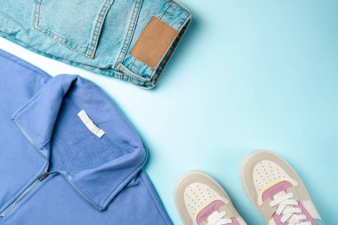 Mavi arka planda gençler için kıyafetler. Gençler için kıyafet. Üst manzara, düz uzanma.