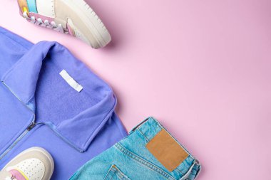 Pembe arka plandaki gençler için kıyafet. Gündelik sokak tarzı, üst bakış açısı, düz yatış.