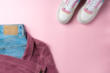 Pembe arka plandaki gençler için kıyafet. Gündelik sokak tarzı, üst bakış açısı, düz yatış.