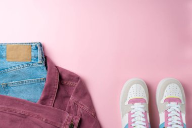Pembe arka plandaki gençler için kıyafet. Gündelik sokak tarzı, üst bakış açısı, düz yatış.