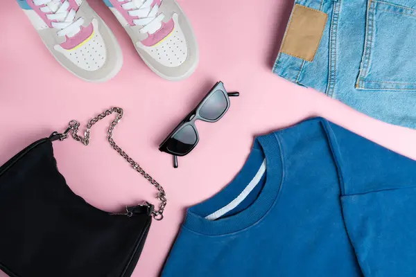 Pembe arka planda kadın kıyafetleri. Moda konsepti. Üst bakış açısı, düz yatış.