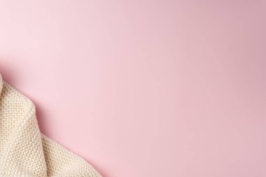 Pembe arka planda örülmüş eşarp. Boşluğu kopyala