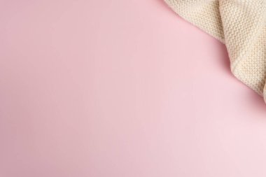 Pembe arka planda örülmüş eşarp. Boşluğu kopyala