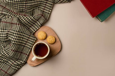 Yumuşak ekoseli kompozisyon, bir fincan çay ve kitap. Boşluğu kopyala