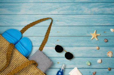 Mavi ahşap arka planda deniz kabukları olan plaj aksesuarları. Üst görünüm, alanı kopyala