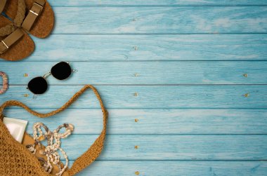 Mavi ahşap arka planda deniz kabukları olan plaj aksesuarları. Üst görünüm, alanı kopyala