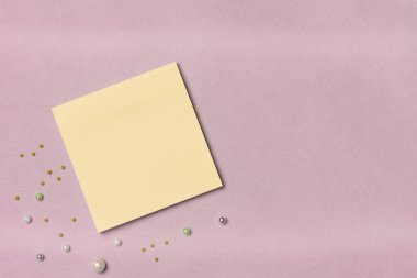 Pembe arka planda dekoru olan sarı kağıt etiketli. Mesaj için yer var. Düz yatış, üst görünüm.
