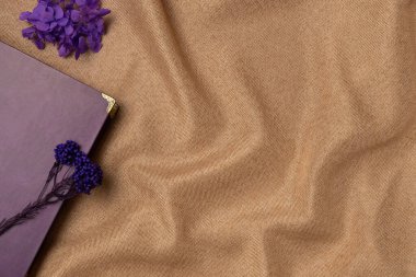 Kumaş arka planında çiçekler olan klasik bir kitap. Boşluğu kopyala