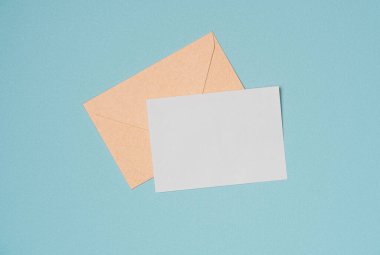 Yukarıdan gelen turkuaz arka planla ilgili zarf ve boş kağıt listesi. Boşluğu kopyala