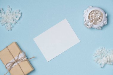 Çiçekli beyaz kağıt liste, hediye kutusu, mavi arka planda inci. Boşluğu kopyala
