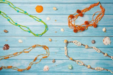 Farklı plaj kolyeleri. Mavi ahşap kaplamalı deniz kabukları olan yaz plajı mücevherleri. Düz yatış, üst görünüm