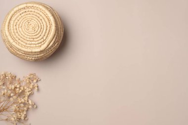 Yukarıdan bej arkaplanlı kurumuş çiçekli saman vazosu. Düz yerde, üst tarafta. Boşluğu kopyala