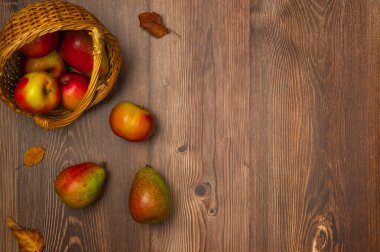 Elmalı sepet ve ahşap arka planda armut. Sonbahar hasadı. Boşluğu kopyala, üst görünüm