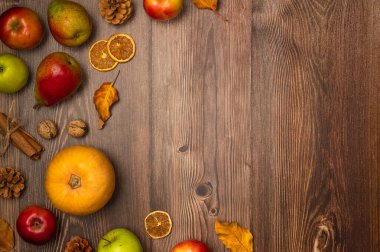 Sonbahar hasadı. Balkabağı, armut, elma, fındık, kozalak, tarçın ve ahşap arka planda yapraklar. Boşluğu kopyala, üst görünüm