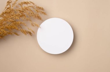 Beyaz yuvarlak podyum, kaide ürünü, bej arka planda kırmızı gül çerçeveli boş maket sunumu