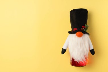 Sarı arka planda cüce kutusunda bir şişe alkol. Noel konsepti. Düz yatış, üst görünüm
