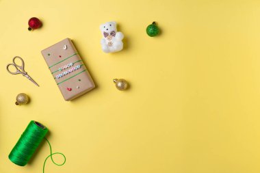 Hediye kutuları, makaslar, ipler ve dekorasyonlarla Noel sarısı arka planı. Hediye paketleme konsepti. Düz yerde, üst tarafta. Boşluğu kopyala