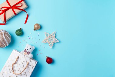 Oyuncak, toplar ve mavi arka planda hediye kutusu olan bir Noel arkaplanı. Düz yerde, üst tarafta. Boşluğu kopyala