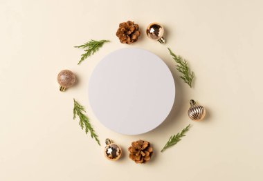 Bej arka planda beyaz yuvarlak podyum. Noel ya da yeni yıl kompozisyonu. Düz yatış, üst görünüm.