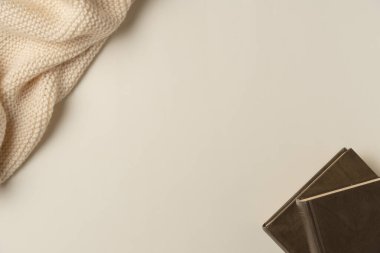 Bej arka planda kitaplar ve eşarp. Uzayı kopyala Düz yatış, üst görünüm