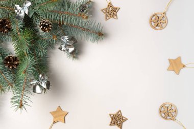 Ağaç dallı Noel çerçevesi ve beyaz arka planda süslemeler. Düz yerde, üst tarafta. Boşluğu kopyala