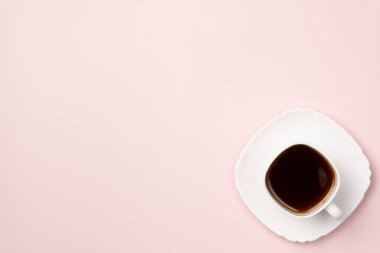 Yukarıdan pembe arka planda bir fincan kahve. Düz yerde, üst tarafta. Boşluğu kopyala