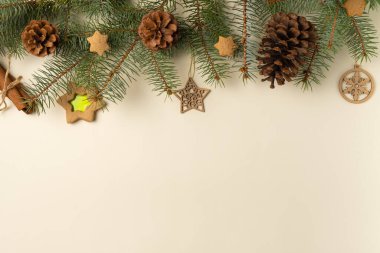 Noel ağacı dalları ve zencefilli kurabiyeli bej arka plan. Düz yerde, üst tarafta. Boşluğu kopyala
