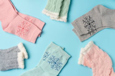 Mavi arka planda farklı kış çorapları. Düz yatış, üst görünüm