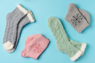 Mavi arka planda farklı kış çorapları. Düz yatış, üst görünüm