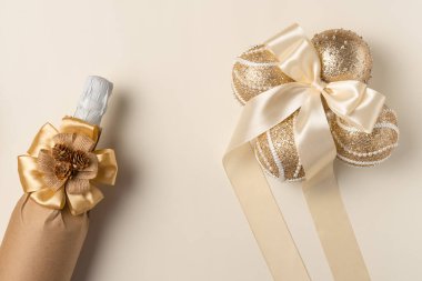 Kabartmalı şampanya şişesi ve bej arka planda Noel süslemesi. Düz yatış, üst görünüm