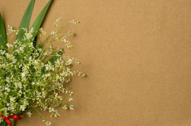 Kumaş arka planda bir buket çiçek. Düz yerde, üst tarafta. Boşluğu kopyala