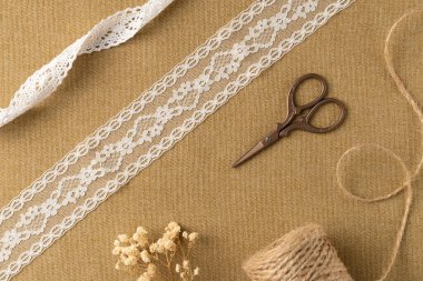 Kumaş zemin üzerinde iplik ve makas olan farklı klasik kurdeleler. Düz yatış, üst görünüm.