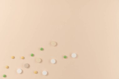 Bej arka planda bir sürü farklı hap var. Düz yerde, üst tarafta. Boşluğu kopyala