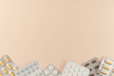 Bej arka planda farklı haplarla su toplamış. Düz yerde, üst tarafta. Boşluğu kopyala