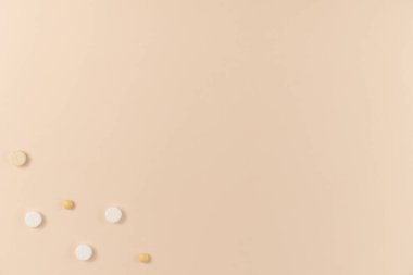 Bej arka planda bir sürü farklı hap var. Düz yerde, üst tarafta. Boşluğu kopyala