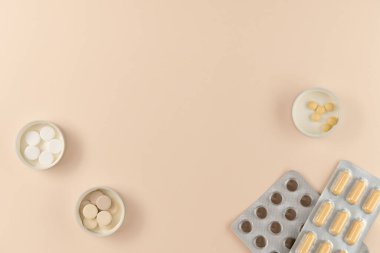 Bej arka planda farklı haplarla su toplamış. Düz yerde, üst tarafta. Boşluğu kopyala