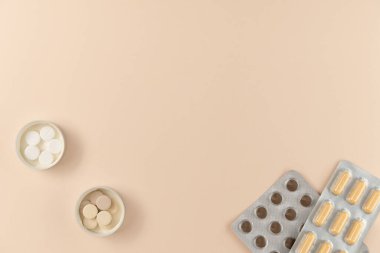 Bej arka planda farklı haplarla su toplamış. Düz yerde, üst tarafta. Boşluğu kopyala