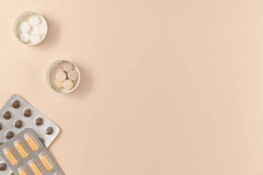 Bej arka planda farklı haplarla su toplamış. Düz yerde, üst tarafta. Boşluğu kopyala