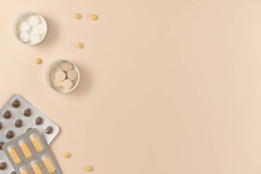 Bej arka planda farklı haplarla su toplamış. Düz yerde, üst tarafta. Boşluğu kopyala