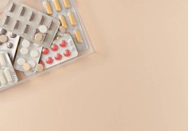 Bej arka planda farklı haplarla su toplamış. Düz yerde, üst tarafta. Boşluğu kopyala