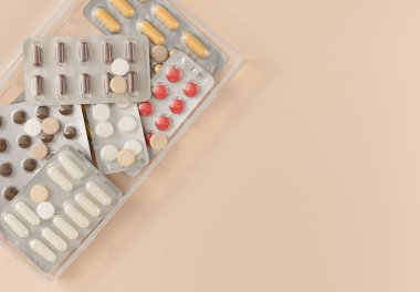 Bej arka planda farklı haplarla su toplamış. Düz yerde, üst tarafta. Boşluğu kopyala