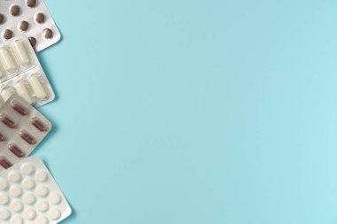 Mavi arka planda farklı haplarla su toplamış. Düz yerde, üst tarafta. Boşluğu kopyala